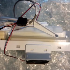 Disassembled white ceiling light fixture with exposed red and black wires and a black connector.