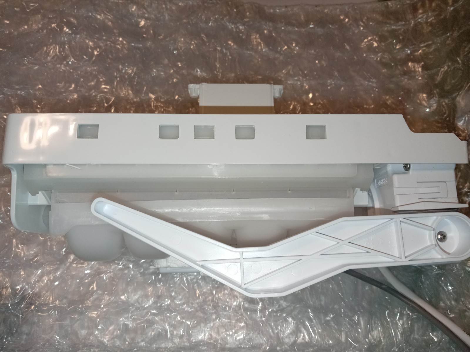 s-l1600-379.jpg White plastic appliance component with a long rectangular body on bubble wrap, incl. an angled support arm.
