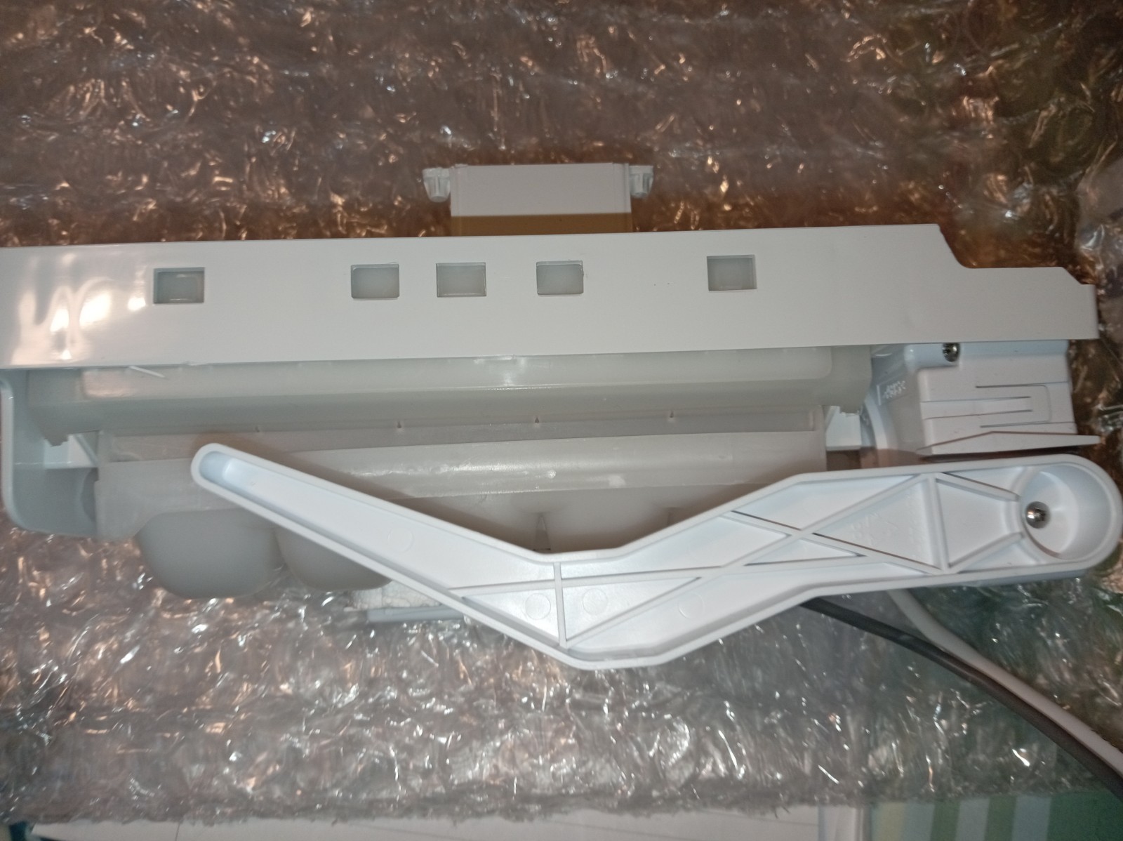 s-l1600-380.jpg Gray plastic printer component with a lever and rails, resting on bubble wrap (likely part of a cartridge or paper tray)