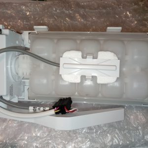 Internal view of a white plastic appliance module with foam padding, a sliding white piece, gray wiring harness, and a black connector.