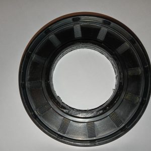Close-up of a black circular mechanical ring with evenly spaced rectangular teeth along the inner and outer edges, viewed from above.