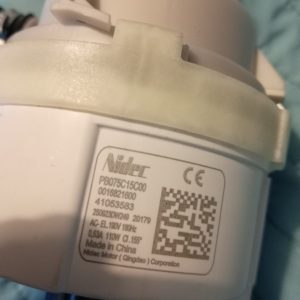 Close-up of a white electric motor housing with a taped seam and a label showing Nidec/CE, QR code, and model number PB075C15C00.