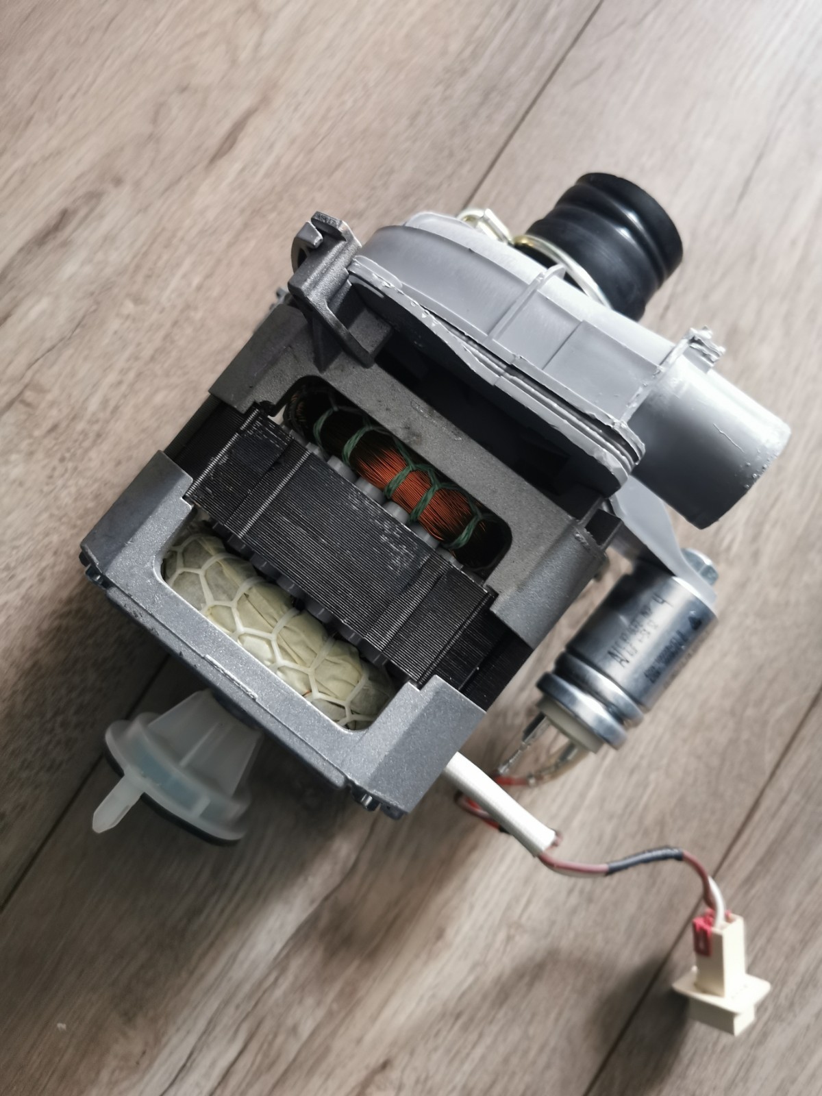s-l1600-495.jpg Close-up of a disassembled electric motor showing copper windings and plastic housing on a wooden surface.