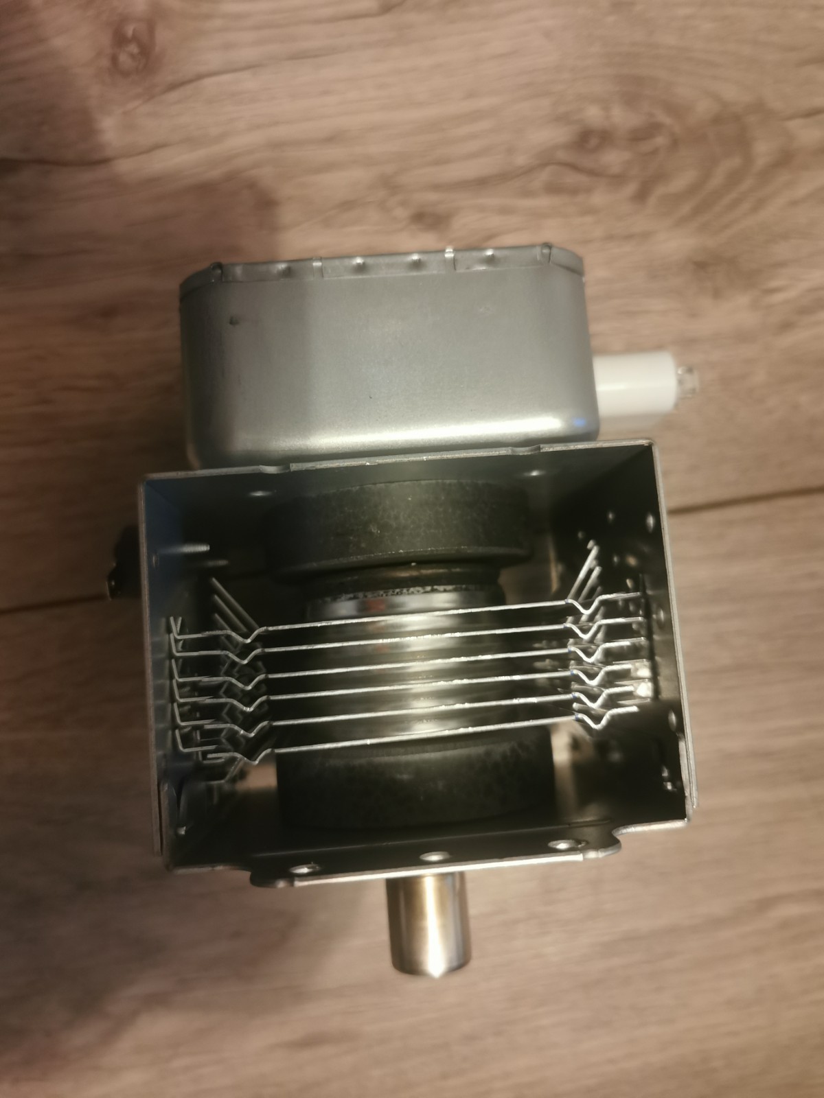 s-l1600-664.jpg Close-up of an electric appliance component: a metal motor housing with a rectangular frame holding parallel metal wires inside. A cylindrical shaft extends from the bottom.