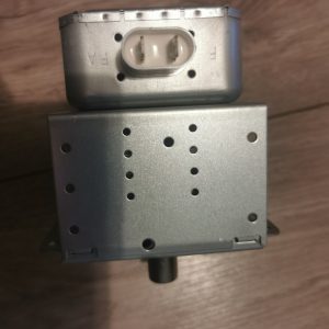 Two-pin white automotive connector on a metal electronic control module with a perforated enclosure (likely a blower or actuator unit).