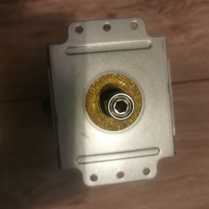 Close-up of a metal lock cylinder set in a metal plate, with a brass ring around a hexagonal key socket