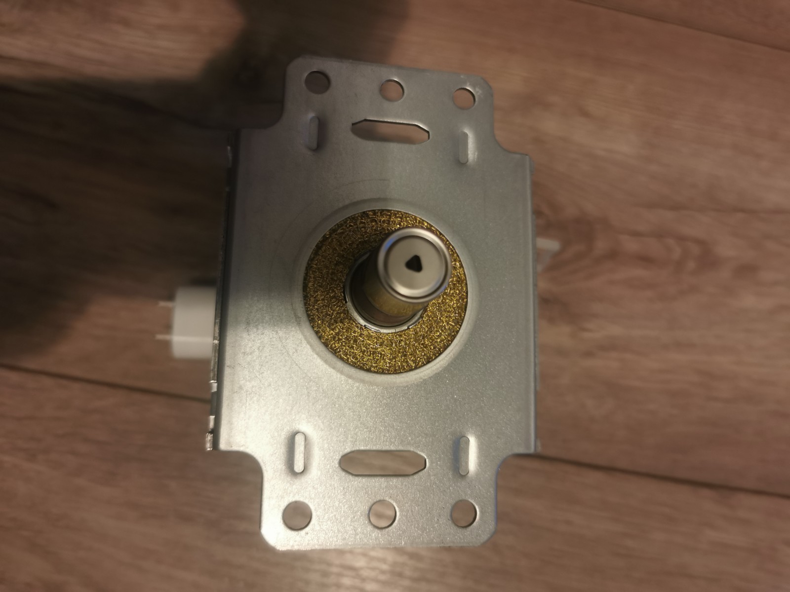 s-l1600-667.jpg Close-up of a silver door lock mechanism with a brass circular housing and central spindle, mounted on a rectangular metal plate viewed from above.
