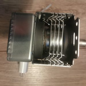 Close-up of an open electro-mechanical device showing stacked metal contact blades inside a rectangular metal housing (relay/switch assembly).