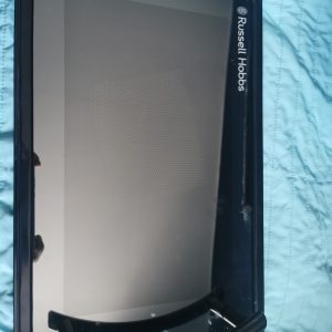 Front view of a Russell Hobbs kitchen appliance with a dark frame and touchscreen panel, resting on a blue quilted surface.