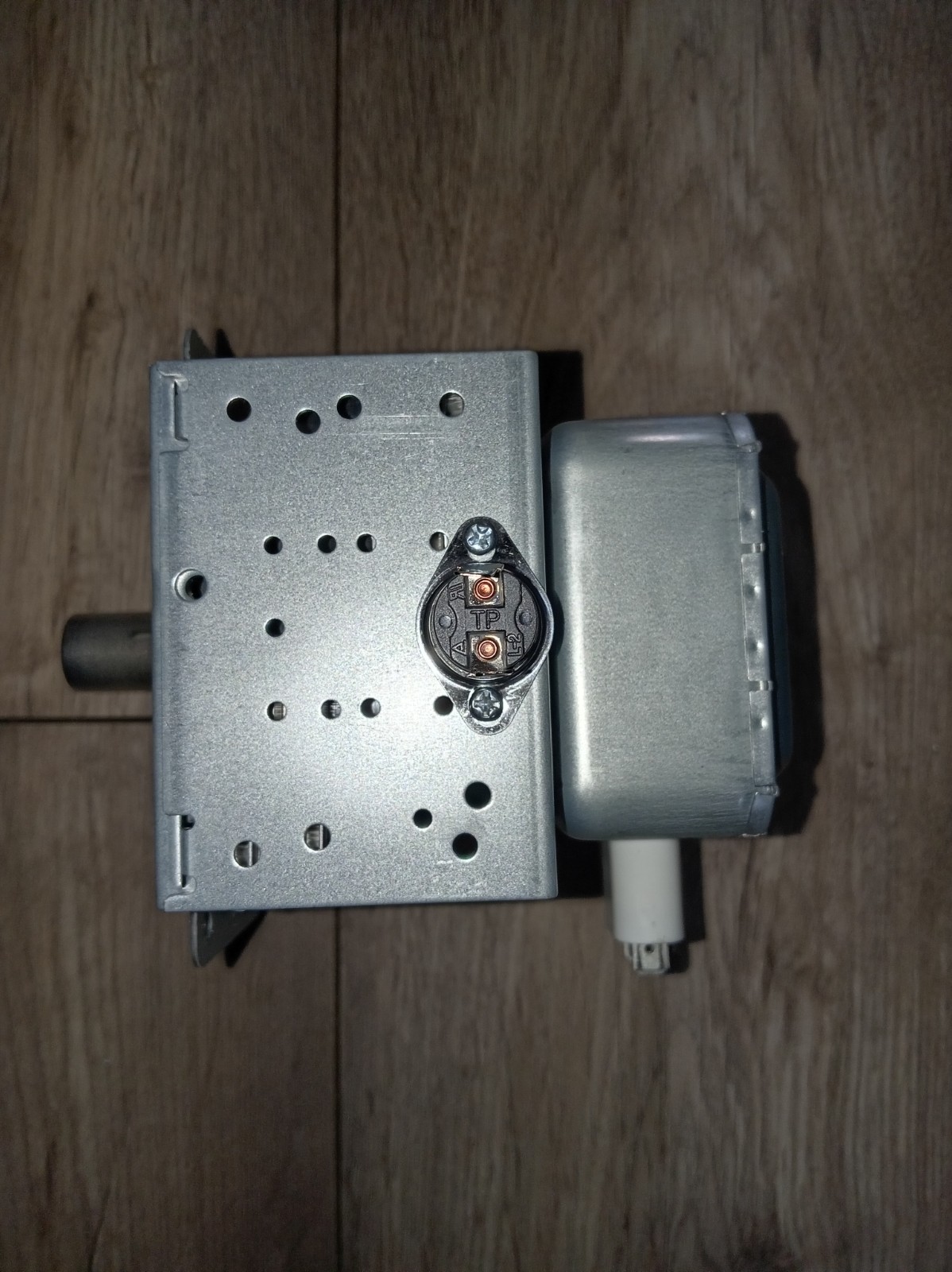 s-l1600-693.jpg Small DC motor with gearbox mounted on a perforated metal housing, with a circular electrical connector and a white cable nearby.