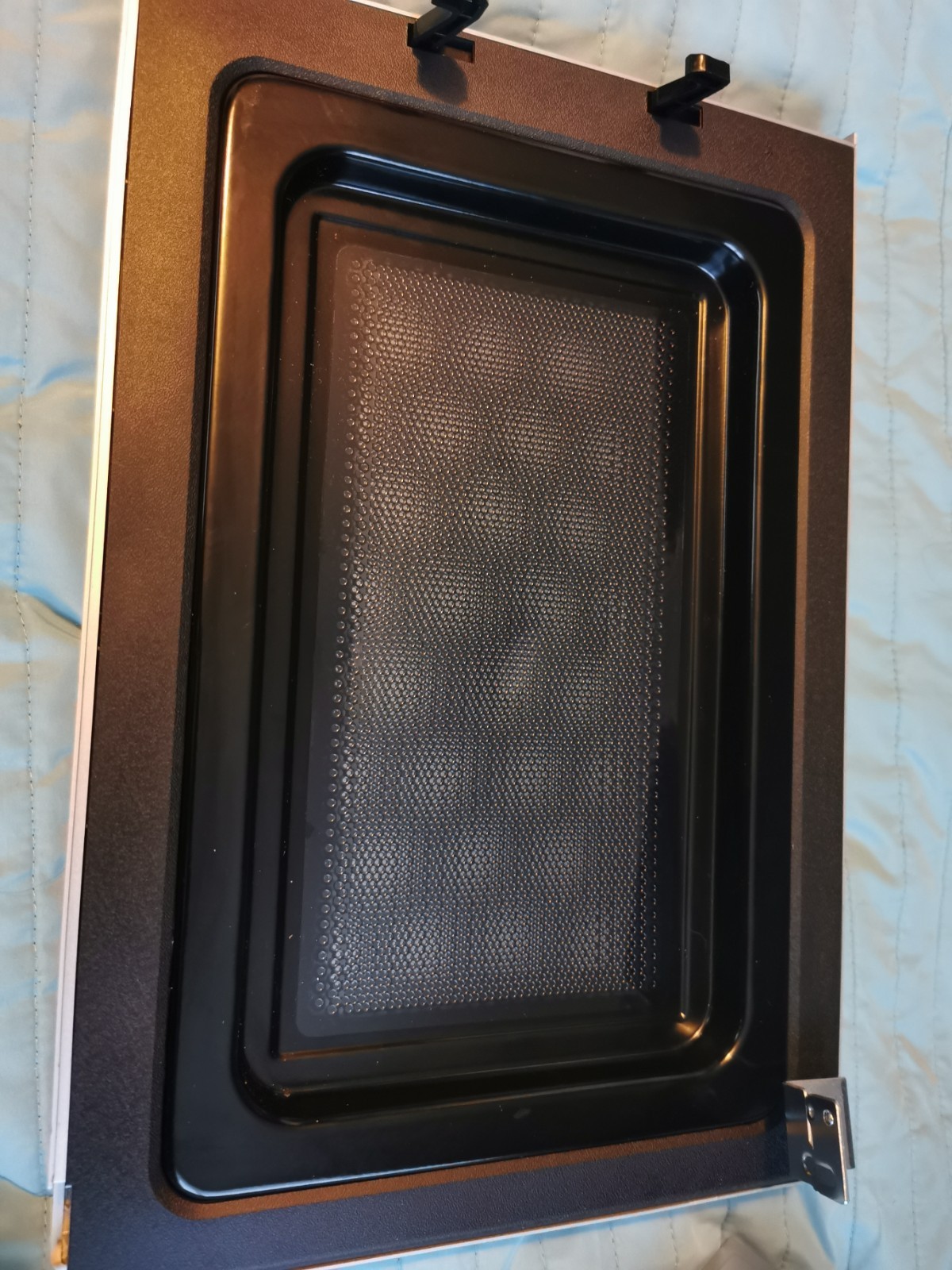 s-l1600-706.jpg Close-up of a black oven interior with a perforated baking tray inside.