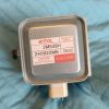 Metal rectangular electrical component with a red-and-white label reading WITOL, Made in China, part numbers 2M539H and 240922M6, and a 'Caution High Voltage Microwave Radiation' warning.