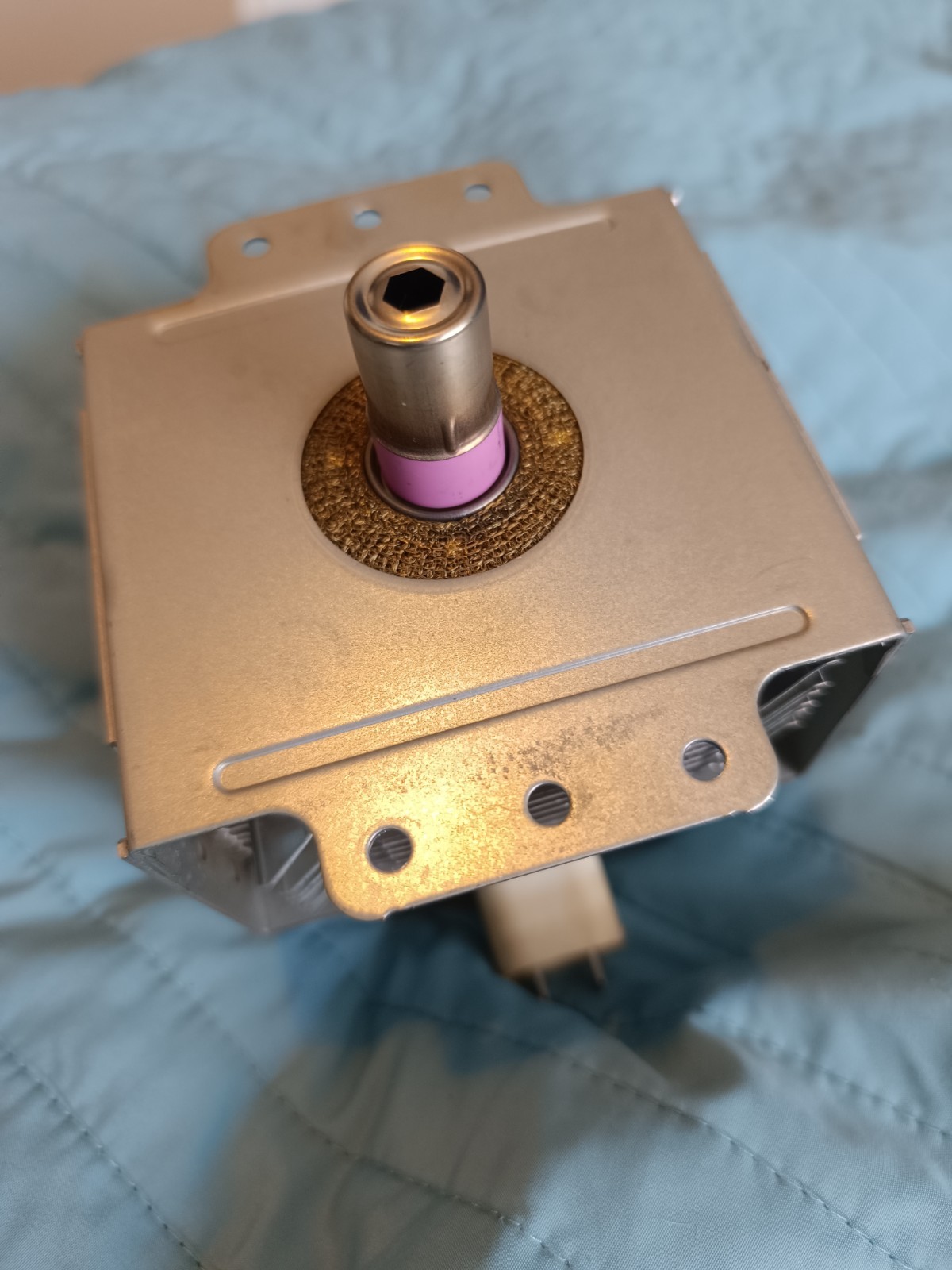 s-l1600-786.jpg Close-up of a metal square actuator housing with a central cylindrical shaft and pink seal around it.