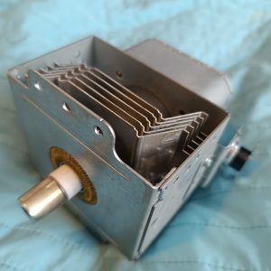 Metal electrical transformer or coil assembly with multiple cooling fins inside a square metal housing and a protruding shaft on the side.