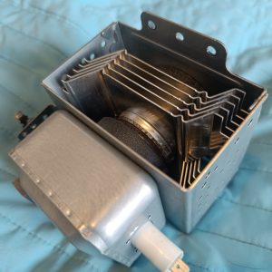 Electrical transformer component with stacked cooling fins and a side mounting bracket on a blue background.
