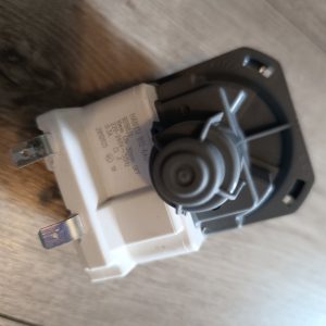 White electrical switch/valve with a round black dial and two metal mounting prongs; appears to be a dimmer or control component.