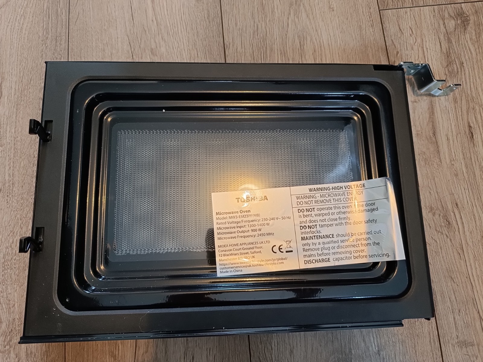 s-l1600-980.jpg Top-down view of an open microwave oven, showing the interior cavity and a warning label on the door edge.